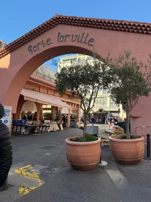 an entrance to a store with two trees in large pots at CANNES: Appartement Cosy à 2 pas de la Croisette in Cannes