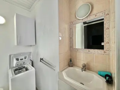 a bathroom with a tub and a sink and a mirror at Louise appartement, by Welcome to Cannes in Cannes