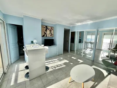 a living room with blue walls and a table and a television at Louise appartement, by Welcome to Cannes in Cannes
