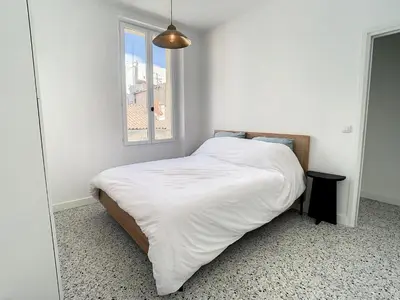 a bedroom with a bed with white sheets and a window at 2 bedroom Majestic, 1 min to the Croisette 357 in Cannes