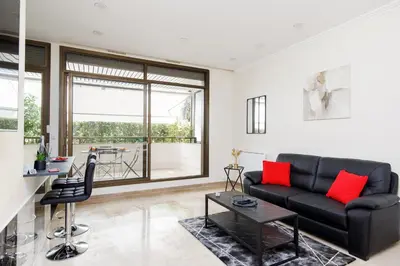 a living room with a black couch and red pillows at Gray d'Albion 1D2 YourHostHelper in Cannes