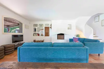 a living room with a blue couch and a tv at Large Provencal villa with swimming pool in lush greenery LIVE IN CANNES in Vallauris