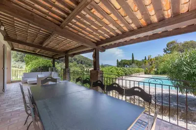 a patio with a table and chairs on a deck at Large Provencal villa with swimming pool in lush greenery LIVE IN CANNES in Vallauris