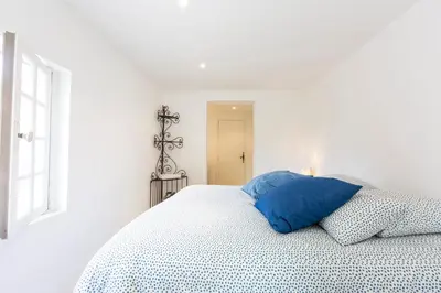 a white bedroom with a blue pillow on a bed at Large Provencal villa with swimming pool in lush greenery LIVE IN CANNES in Vallauris