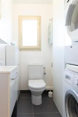 a white bathroom with a toilet and a window at Ideal congress and vacation LIVE IN VILLA PARADOR in Cannes