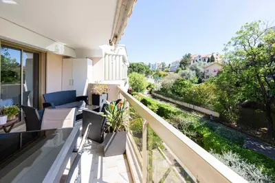 an apartment balcony with a view of a garden at Ideal congress and vacation LIVE IN VILLA PARADOR in Cannes