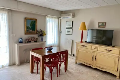 a living room with a table and a tv at Cannes Palm Beach Top Floor Terrace ! SAINT JAMES in Cannes