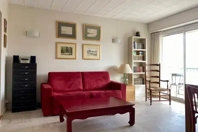 a living room with a red couch and a table at Cannes Palm Beach Top Floor Terrace ! SAINT JAMES in Cannes