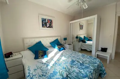 a bedroom with a bed with blue sheets and a mirror at 2 rooms facing south 300m from the Croisette LIVE IN LE BOSQUET in Cannes