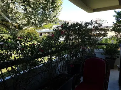 a balcony with a bunch of plants and a chair at 80m2 dans Parc Classé, Piscine, Calme, 5mn de Cannes in Le Cannet