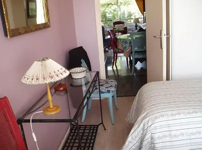 a bedroom with a lamp on a table next to a bed at 80m2 dans Parc Classé, Piscine, Calme, 5mn de Cannes in Le Cannet