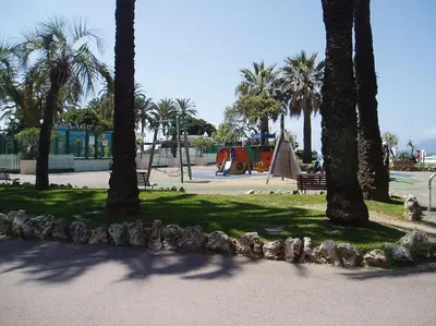 a park with palm trees and a playground at 80m2 dans Parc Classé, Piscine, Calme, 5mn de Cannes in Le Cannet