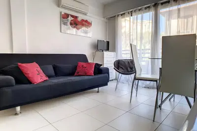 a living room with a blue couch and a table at HENRI CAMILLE REAL ESTATE - Rouaze - Studio 50m Croisette in Cannes