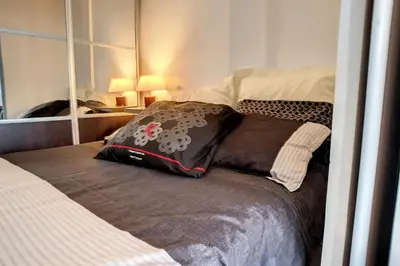 a bed with a pillow on it in a bedroom at HENRI CAMILLE REAL ESTATE - Rouaze - Studio 50m Croisette in Cannes