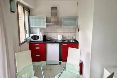 a small kitchen with a glass table and a microwave at HENRI CAMILLE REAL ESTATE - Rouaze - Studio 50m Croisette in Cannes