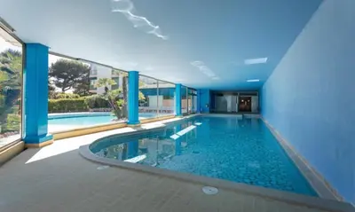 a swimming pool in a building with a large window at Residence Eden park in Cannes