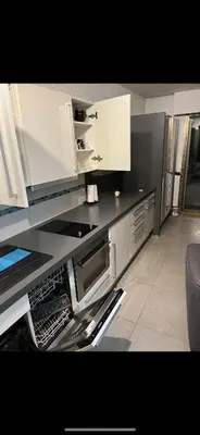 a kitchen with white cabinets and a dishwasher at Residence Eden park in Cannes