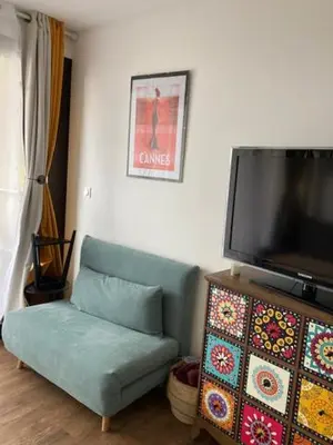 a living room with a couch and a flat screen tv at Profitez du Festival du Soleil de Cannes in Cannes