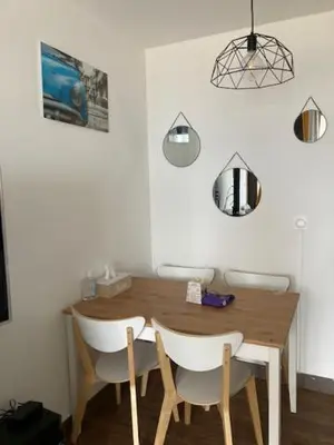 a dining room table with white chairs and a wooden table at Profitez du Festival du Soleil de Cannes in Cannes