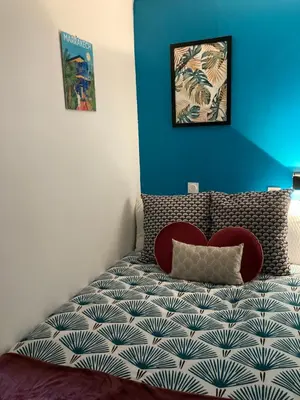 a bedroom with a bed with a pillow and a blue wall at Profitez du Festival du Soleil de Cannes in Cannes