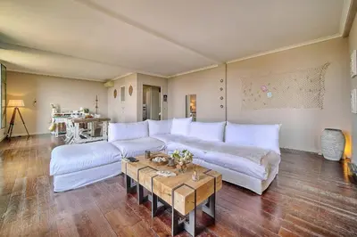a living room with a white couch and a table at IMMOGROOM - Large Apartment - Parking - Air conditioning - Sea view - Wifi in Cannes