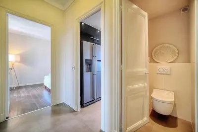 a bathroom with a toilet and a door to a bedroom at IMMOGROOM - Large Apartment - Parking - Air conditioning - Sea view - Wifi in Cannes