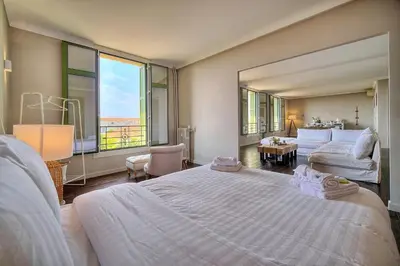 a bedroom with a large bed and a large window at IMMOGROOM - Large Apartment - Parking - Air conditioning - Sea view - Wifi in Cannes