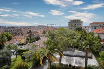 a view of a city with palm trees and buildings at IMMOGROOM - Large Apartment - Parking - Air conditioning - Sea view - Wifi in Cannes