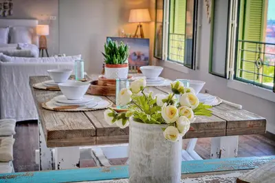 a dining room table with flowers in a vase at IMMOGROOM - Large Apartment - Parking - Air conditioning - Sea view - Wifi in Cannes