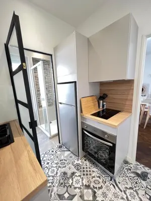 a small kitchen with a stove and a refrigerator at LOENA CANNES CENTRE - 2 pièces rénové - 4 personnes - proche croisette palais festival plage - internet gratuit - climatisation - non fumeur in Cannes