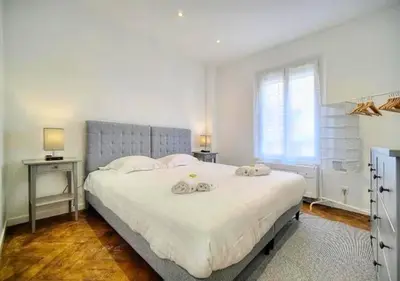 a bedroom with a large bed with two towels on it at LOENA CANNES CENTRE - 2 pièces rénové - 4 personnes - proche croisette palais festival plage - internet gratuit - climatisation - non fumeur in Cannes