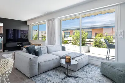 a living room with a couch and a large window at LUXURIOUS PENTHOUSE ROOFTOP MARTINEZ CROISETTE in Cannes
