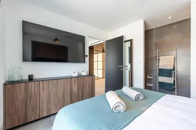 a bedroom with a large bed with a flat screen tv at LUXURIOUS PENTHOUSE ROOFTOP MARTINEZ CROISETTE in Cannes