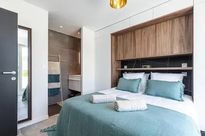 a bedroom with a large bed with blue pillows on it at LUXURIOUS PENTHOUSE ROOFTOP MARTINEZ CROISETTE in Cannes