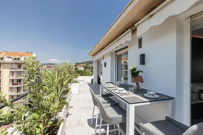 a balcony with a table and chairs on a building at LUXURIOUS PENTHOUSE ROOFTOP MARTINEZ CROISETTE in Cannes