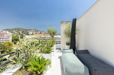 a balcony with couches and plants on a building at LUXURIOUS PENTHOUSE ROOFTOP MARTINEZ CROISETTE in Cannes