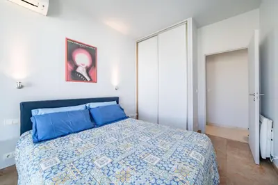 a bedroom with a bed with blue pillows at Palm beach- Free Wifi- Parking- Sea View in Cannes