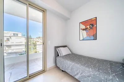 a bedroom with a bed and a large window at Palm beach- Free Wifi- Parking- Sea View in Cannes