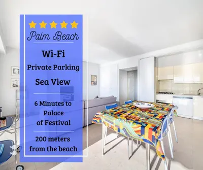 a kitchen with a table with blue chairs and a kitchen with a refrigerator at Palm beach- Free Wifi- Parking- Sea View in Cannes
