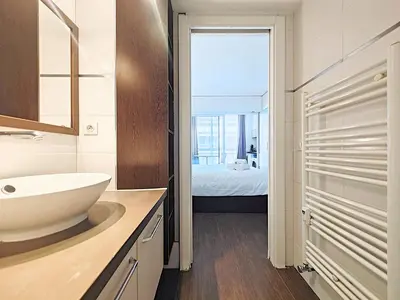 a bathroom with a sink and a bedroom at Viva Riviera Studio General Ferrié in Cannes