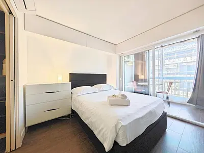 a white bedroom with a large bed with a white dresser at Viva Riviera Studio General Ferrié in Cannes