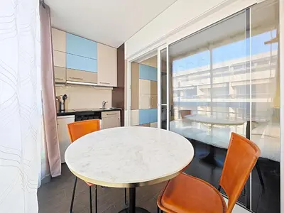 a kitchen with a white table and chairs in a room at Viva Riviera Studio General Ferrié in Cannes