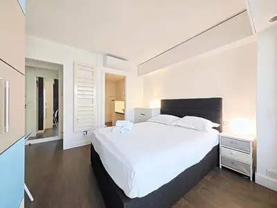 a white bedroom with a large white bed with white sheets at Viva Riviera Studio General Ferrié in Cannes