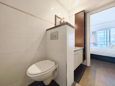 a white bathroom with a toilet and a bed at Viva Riviera Studio General Ferrié in Cannes