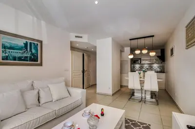 a living room with a white couch and a table at Appartement Clap d'Or - Welkeys in Cannes