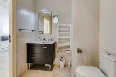 a bathroom with a sink and a toilet and a mirror at Appartement Clap d'Or - Welkeys in Cannes