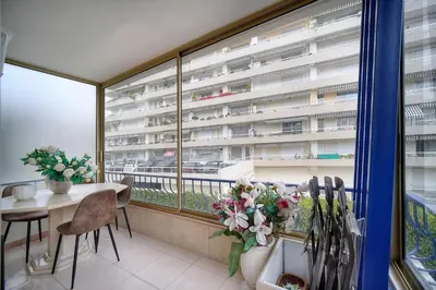 a balcony with a table and chairs and a large window at IMMOGROOM - 2 BR - Air conditioning - Wifi - Terrace - Common parking in Cannes