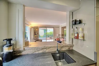 a kitchen with a sink and a view of a living room at IMMOGROOM - 2 BR - Air conditioning - Wifi - Terrace - Common parking in Cannes
