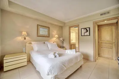 a bedroom with a large white bed with towels on it at IMMOGROOM - 2 BR - Air conditioning - Wifi - Terrace - Common parking in Cannes