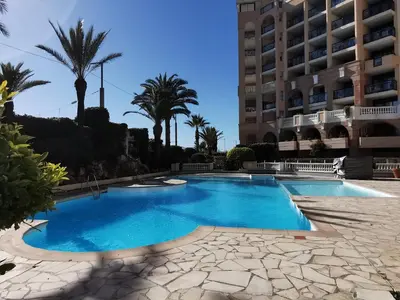 a swimming pool in front of a building at Appartement en bord de mer in Cannes